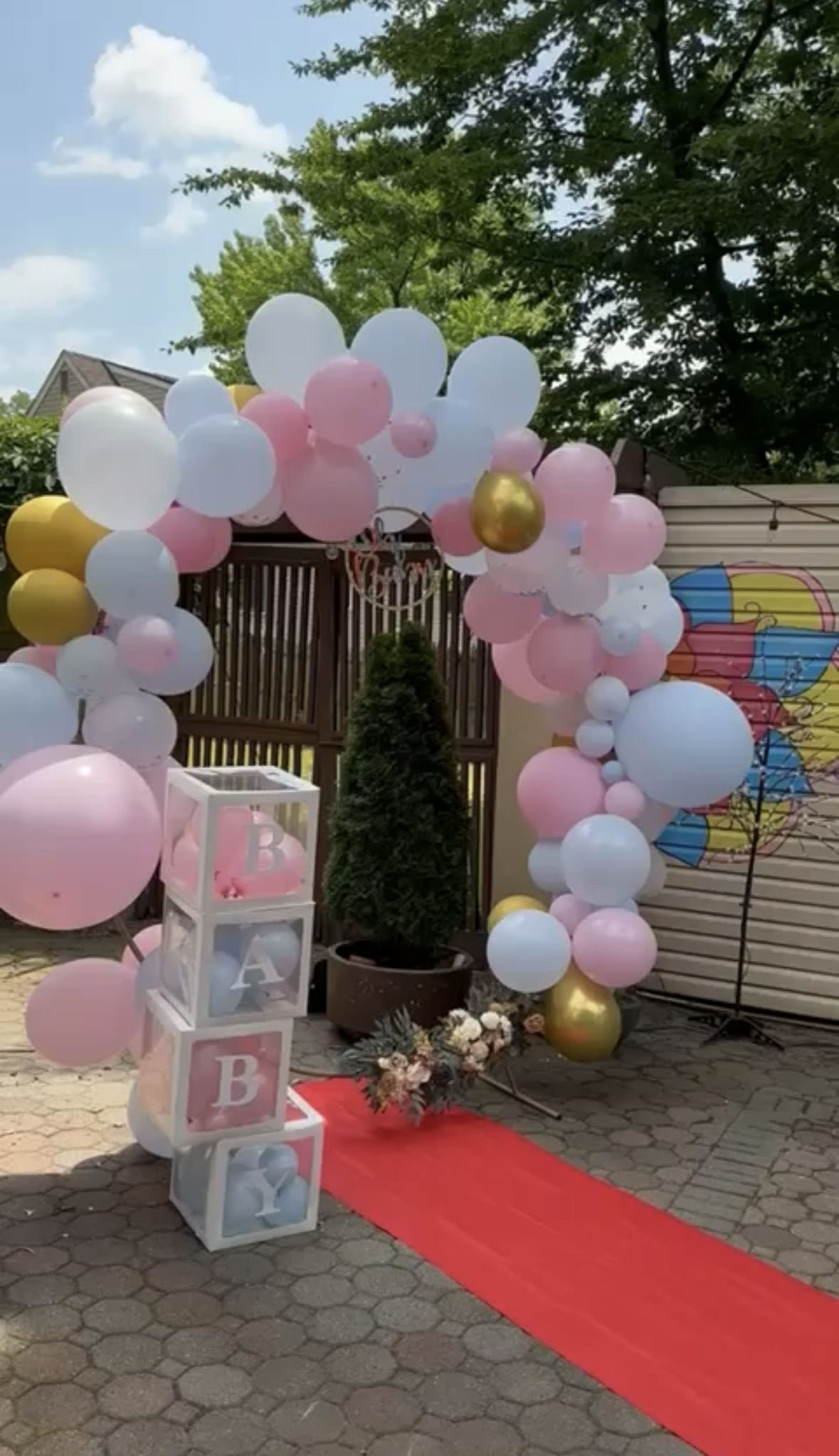 Gender reveal celebration setup with balloons and signage
