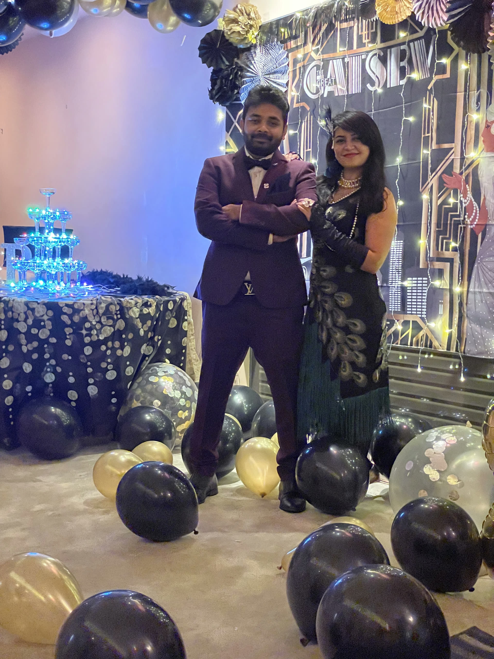 Guests celebrating in front of a balloon and cake display