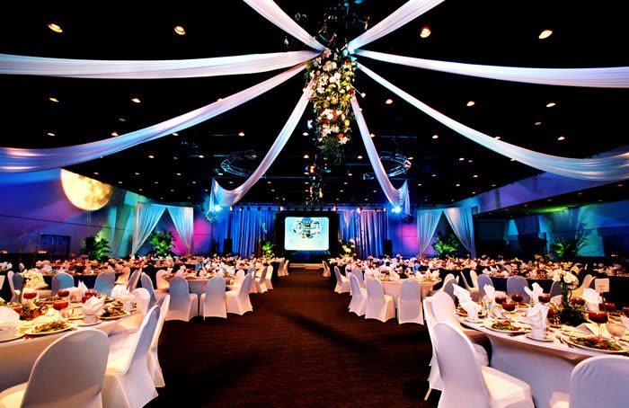 Corporate banquet hall with draped ceiling and screens